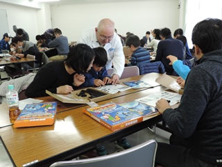 天体望遠鏡作成の説明書を読む親子の写真